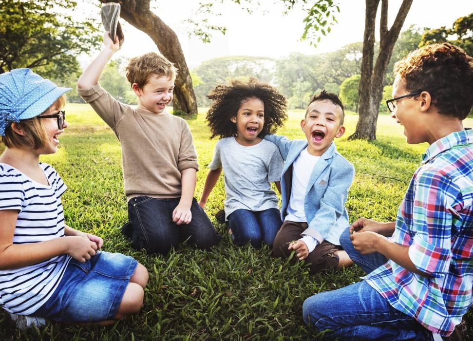 group of young kids laughing in the grass