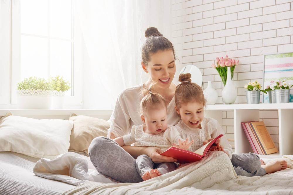 woman reading to her two young children