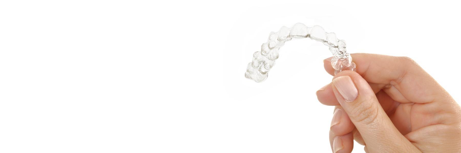 woman's hand holding Invisalign