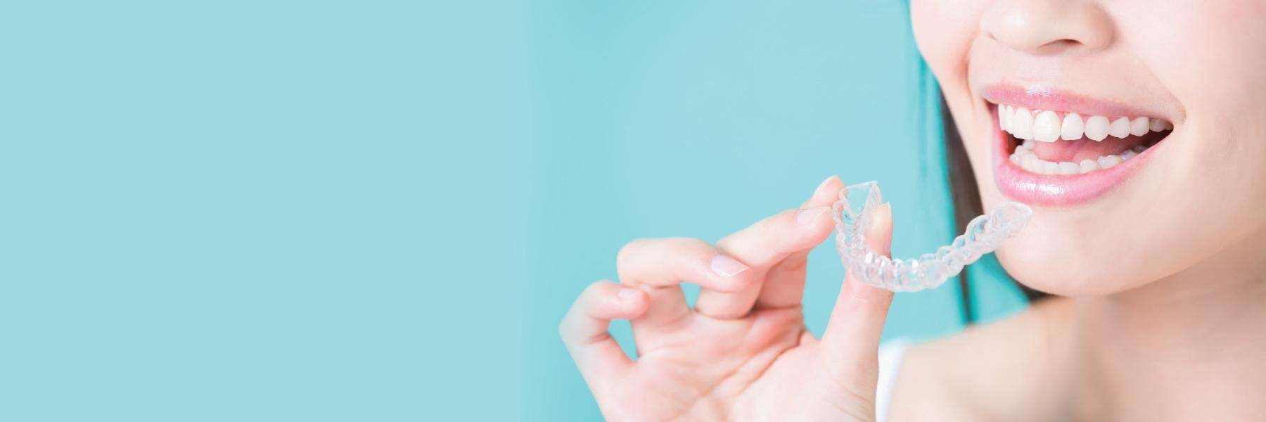 A Lady holding Invisalign clear aligners at Skyvalley Dental in Monroe, WA.